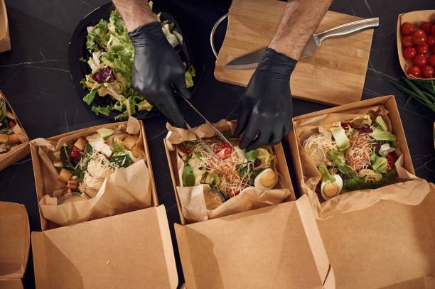 Chef preparing takeout catering boxes in the kitchen